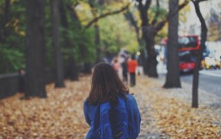 Jeune fille marchant dans les feuilles d'automne